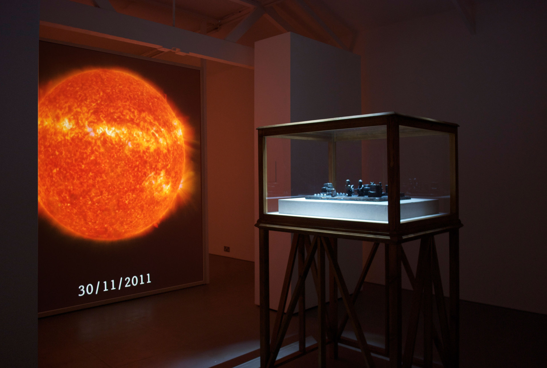 SO-LA, 2012, digital video, duration variable, 'Reconstruction of a 12th century BC Elamite antiquity, Sit Shamsi', 2012, bronze,(w. 53 cm x h. 12 cm x d. 35 cm) with 'Vitrine', 2012, timber, acrylic, linen, (w. 100 cm x h. 165 cm x d. 79 cm)